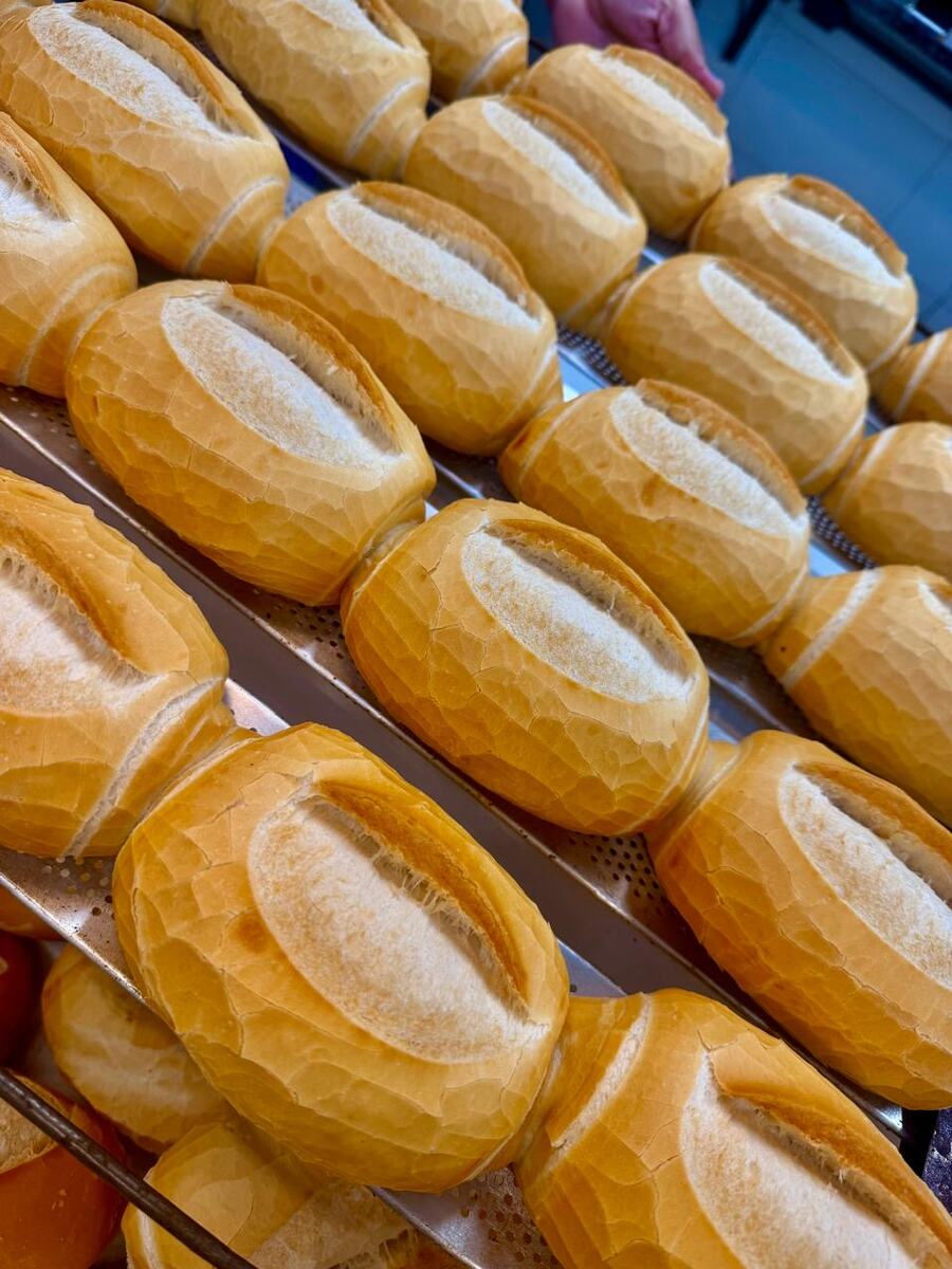 Pães franceses dourados enfileirados em assadeira na padaria da Astra Mix